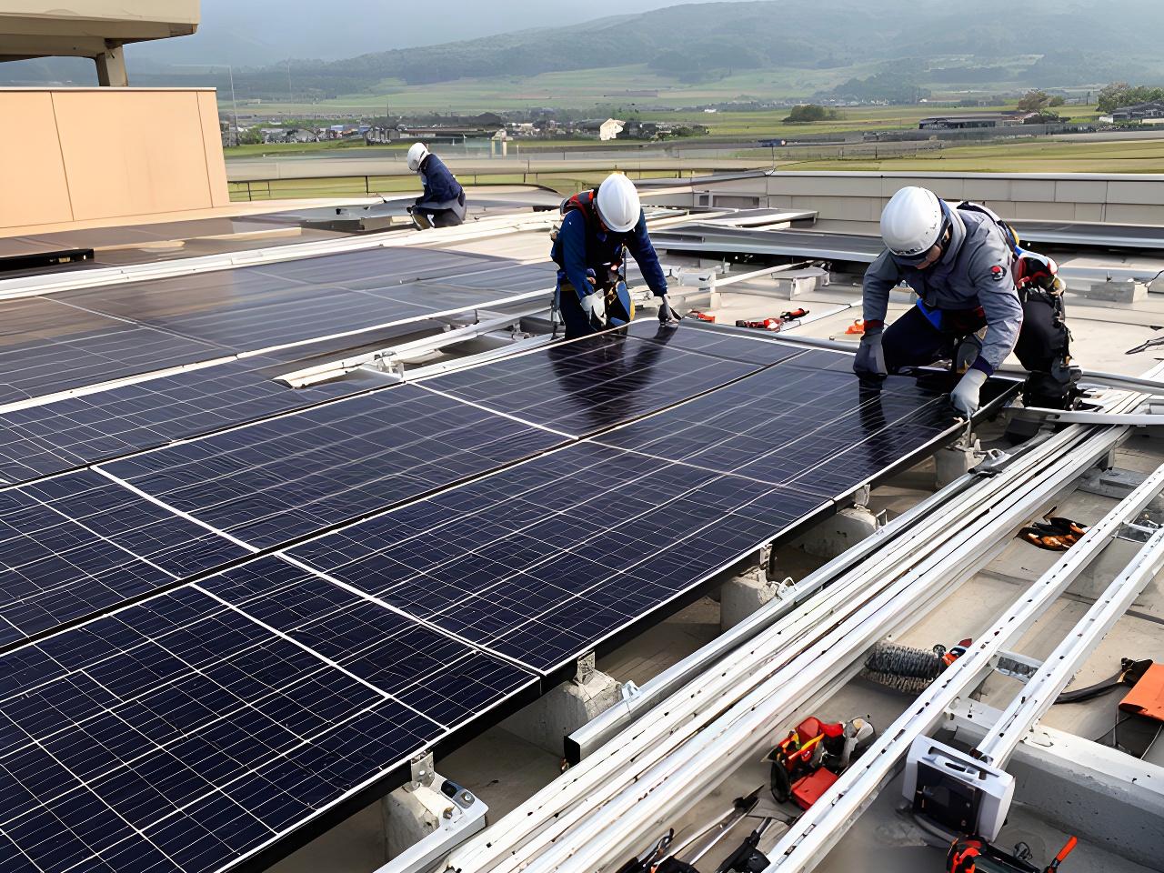 長野県の事業所屋根で太陽光発電設備を施工する作業員と設置中のパネル